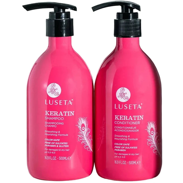Two bright pink Luseta Keratin hair care bottles on a white surface with a blurred metal rack and light background behind them. The left bottle is Keratin Shampoo and the right bottle is Keratin Conditioner, both with black pump dispensers.