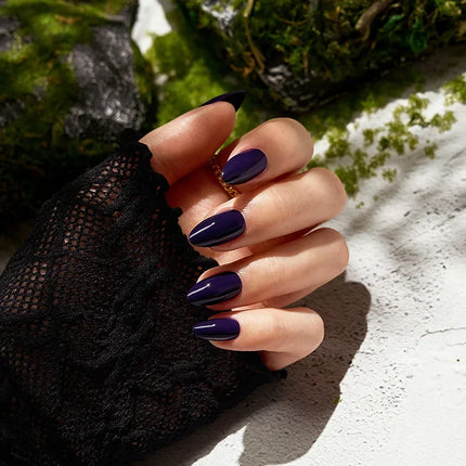 Manicure look featuring BTArtboxnails Storm Black medium almond press on nails, showing a professional, elongated salon finish on natural hands.