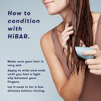 Person conditioning hair with HiBAR product on a light blue background